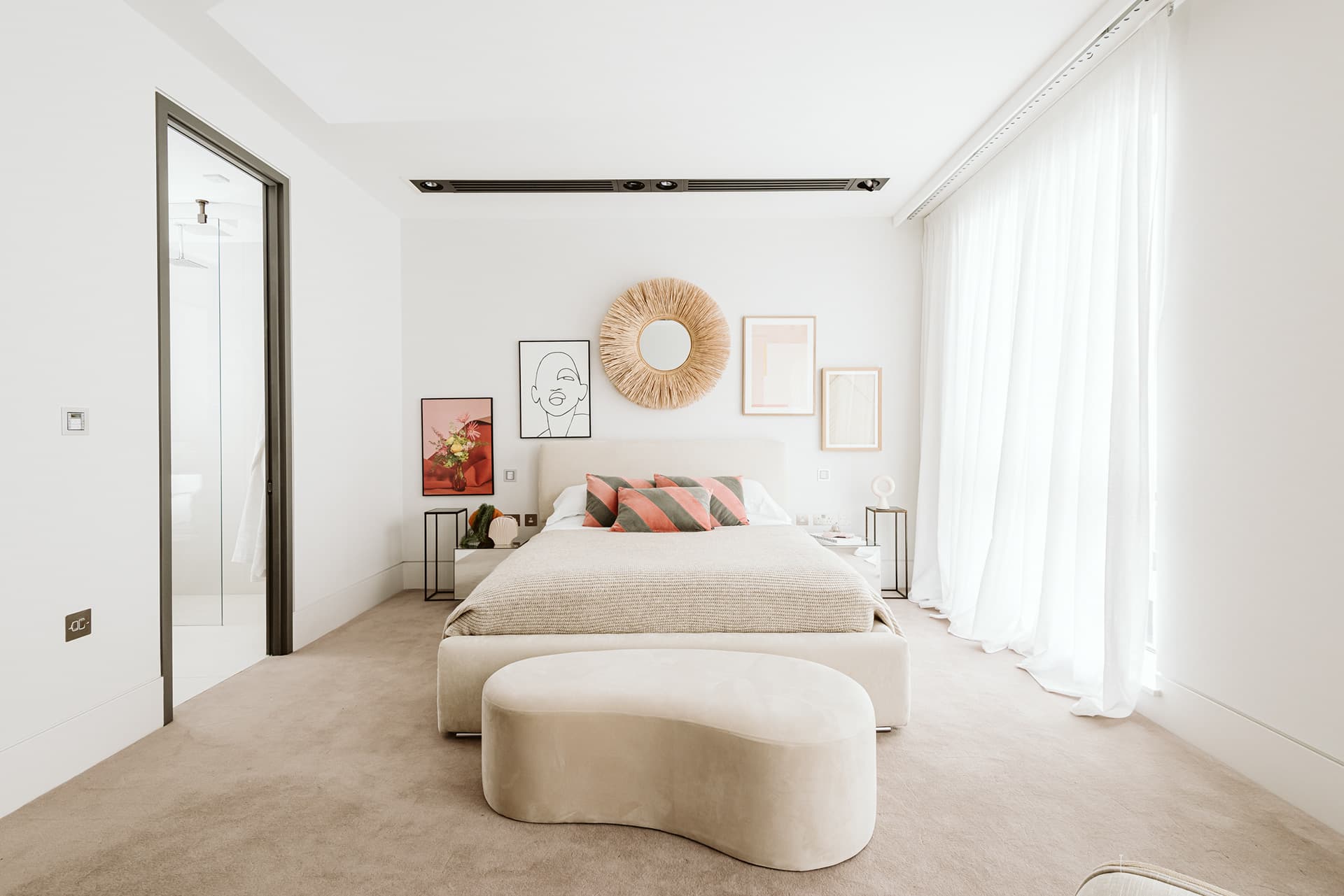 Luxury London bedroom with gallery wall and sheer floor-length curtains