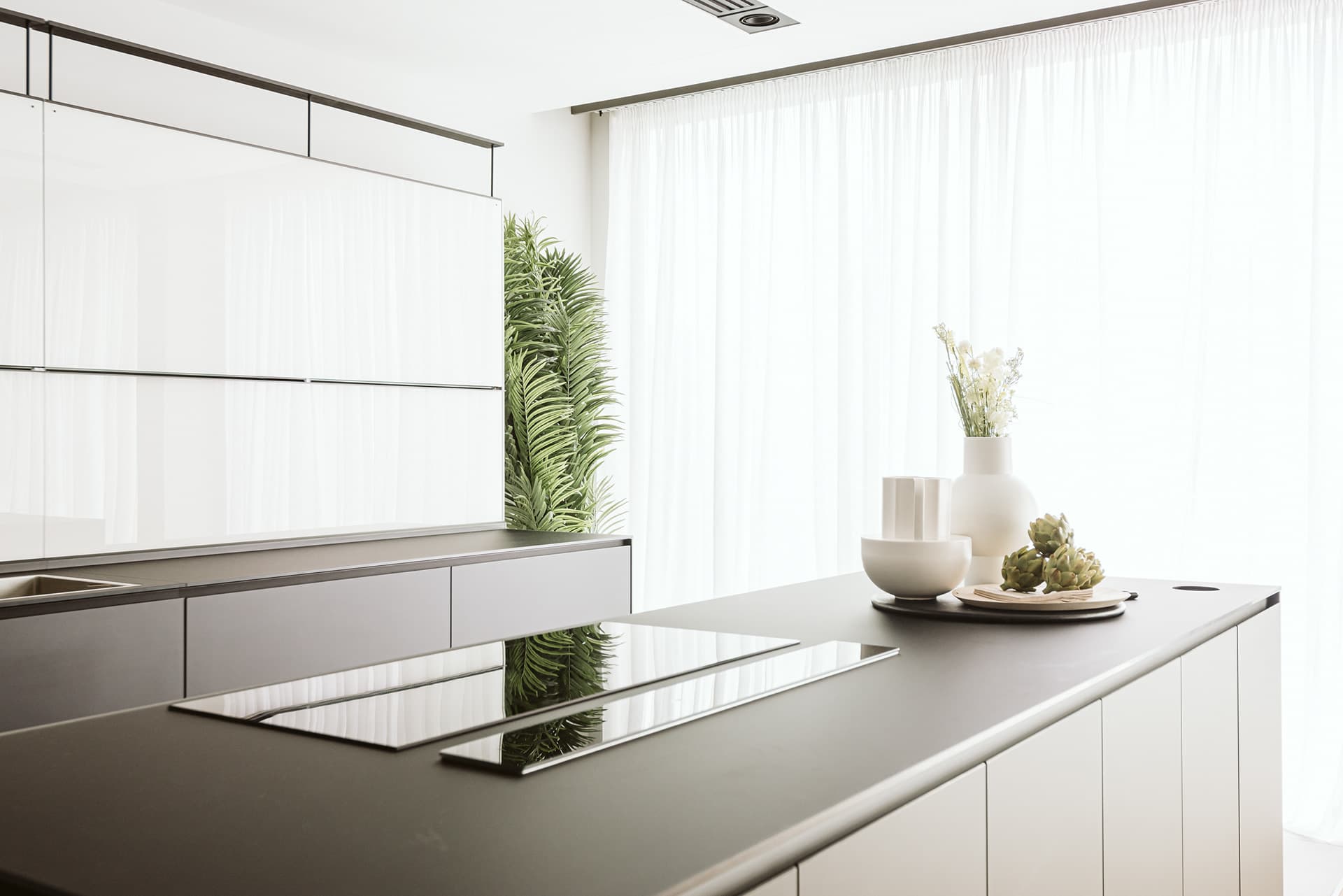 Contemporary London kitchen with dark stone island and sheer curtains