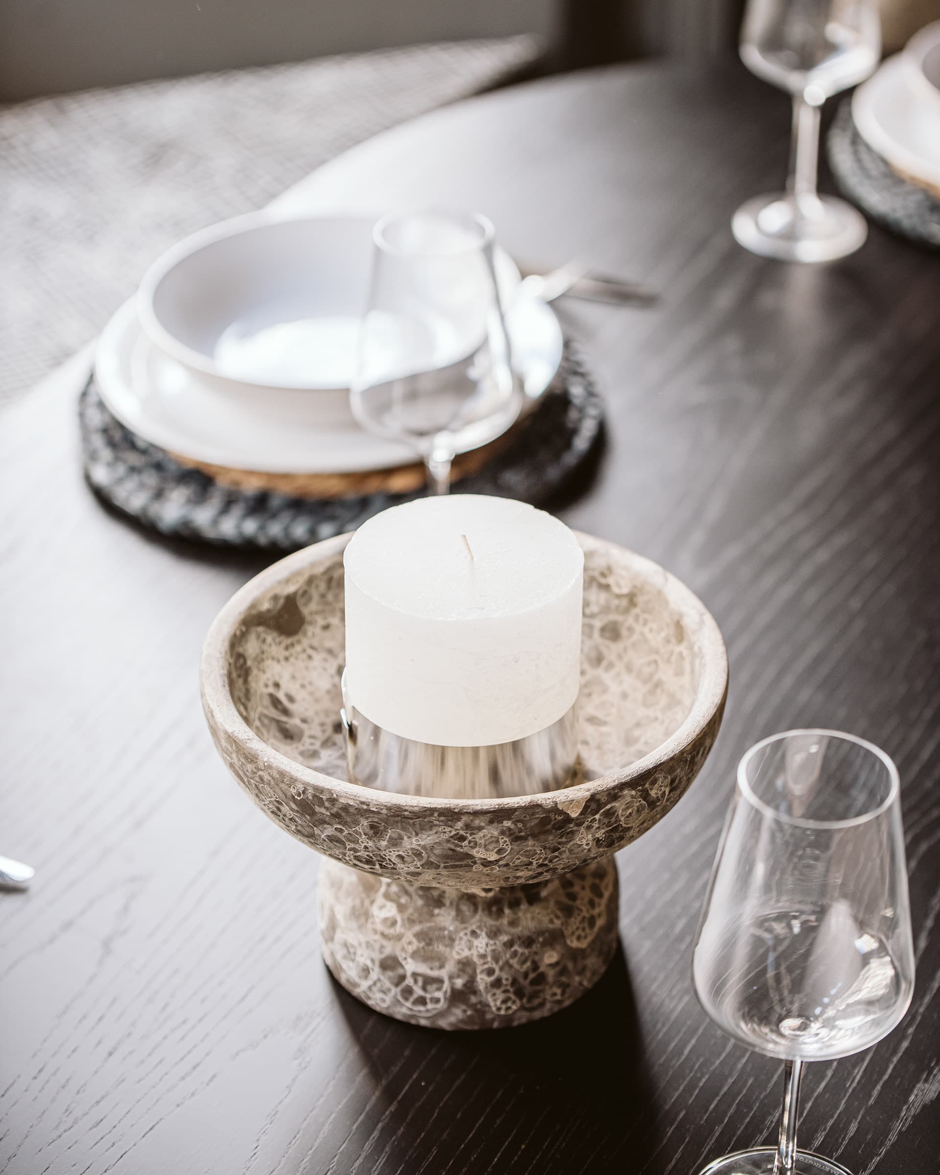 Dining table setting with stone candle holder and crystal glassware